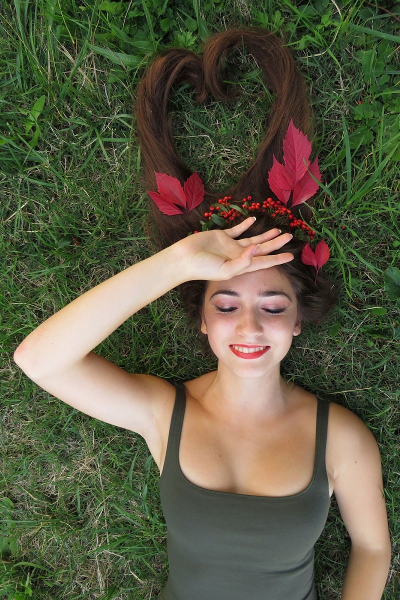 Jeune femme heureuse couchée dans l'herbe