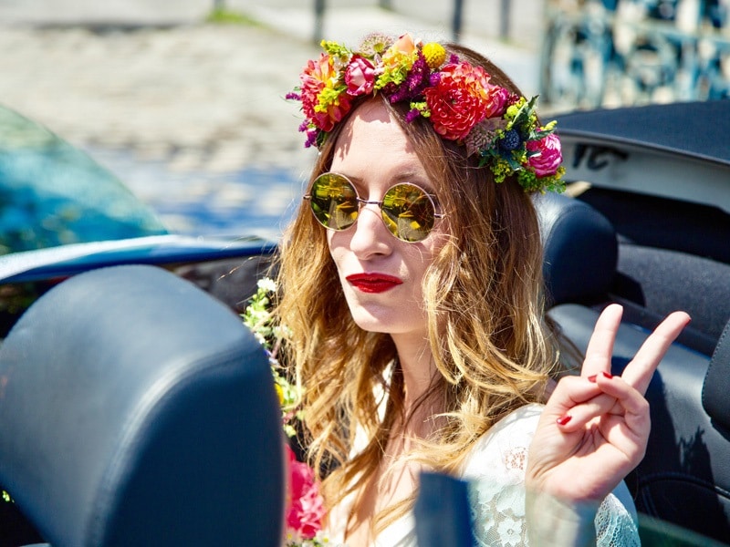Une mariée avec une couronne à fleur dans une voiture